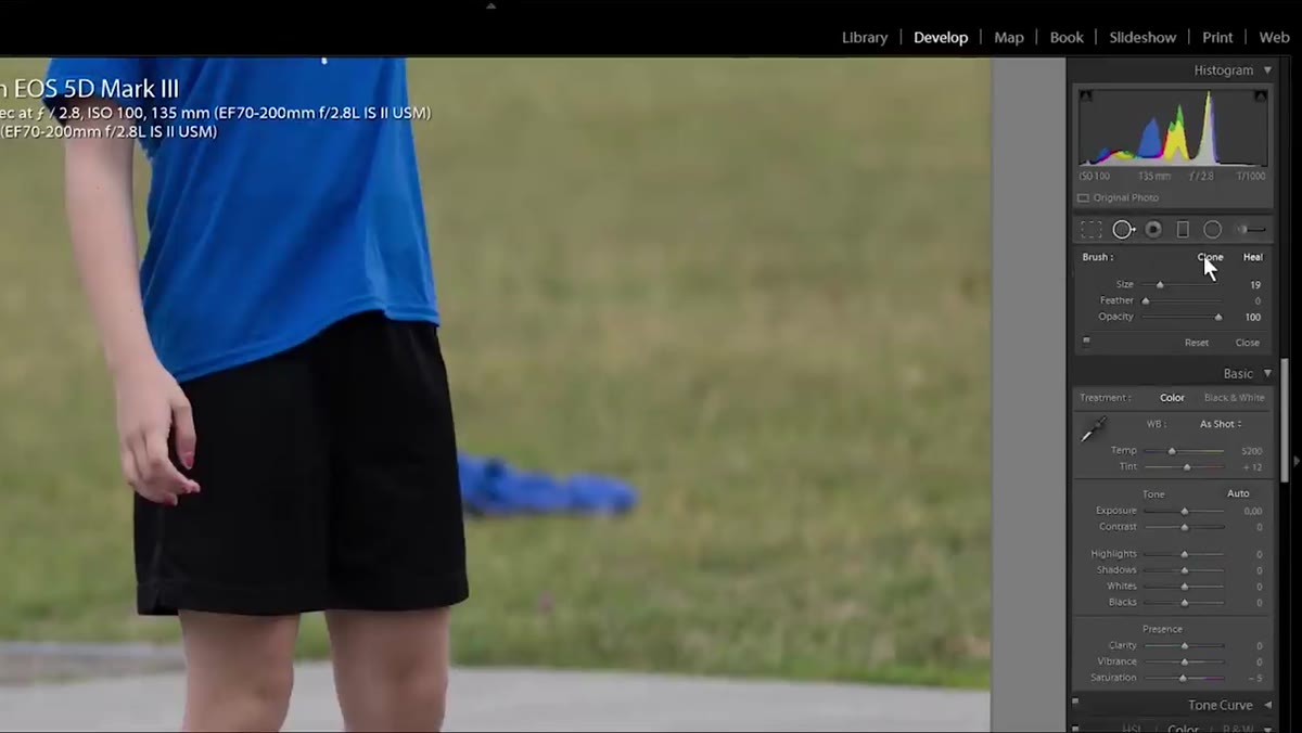 Clone tool selected with a small brush near a subject&rsquo;s leg