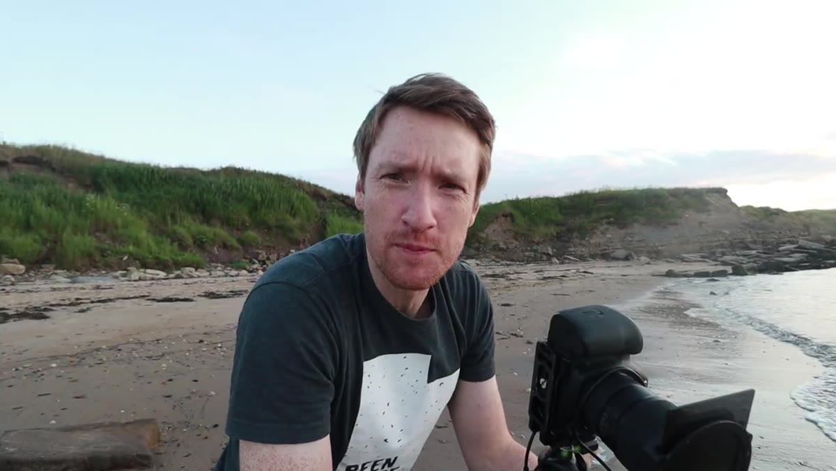 Thomas positioning tripod near a pointy rock with water movement