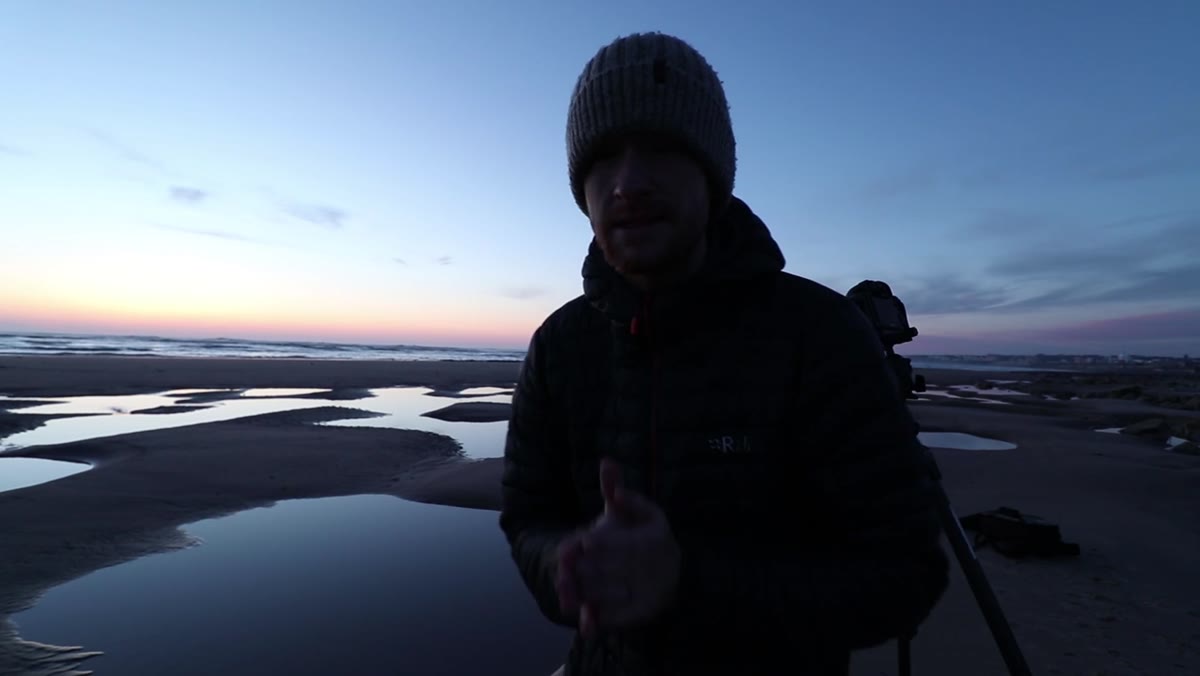 Wide foreground tide pool dominating lower two-thirds of the frame